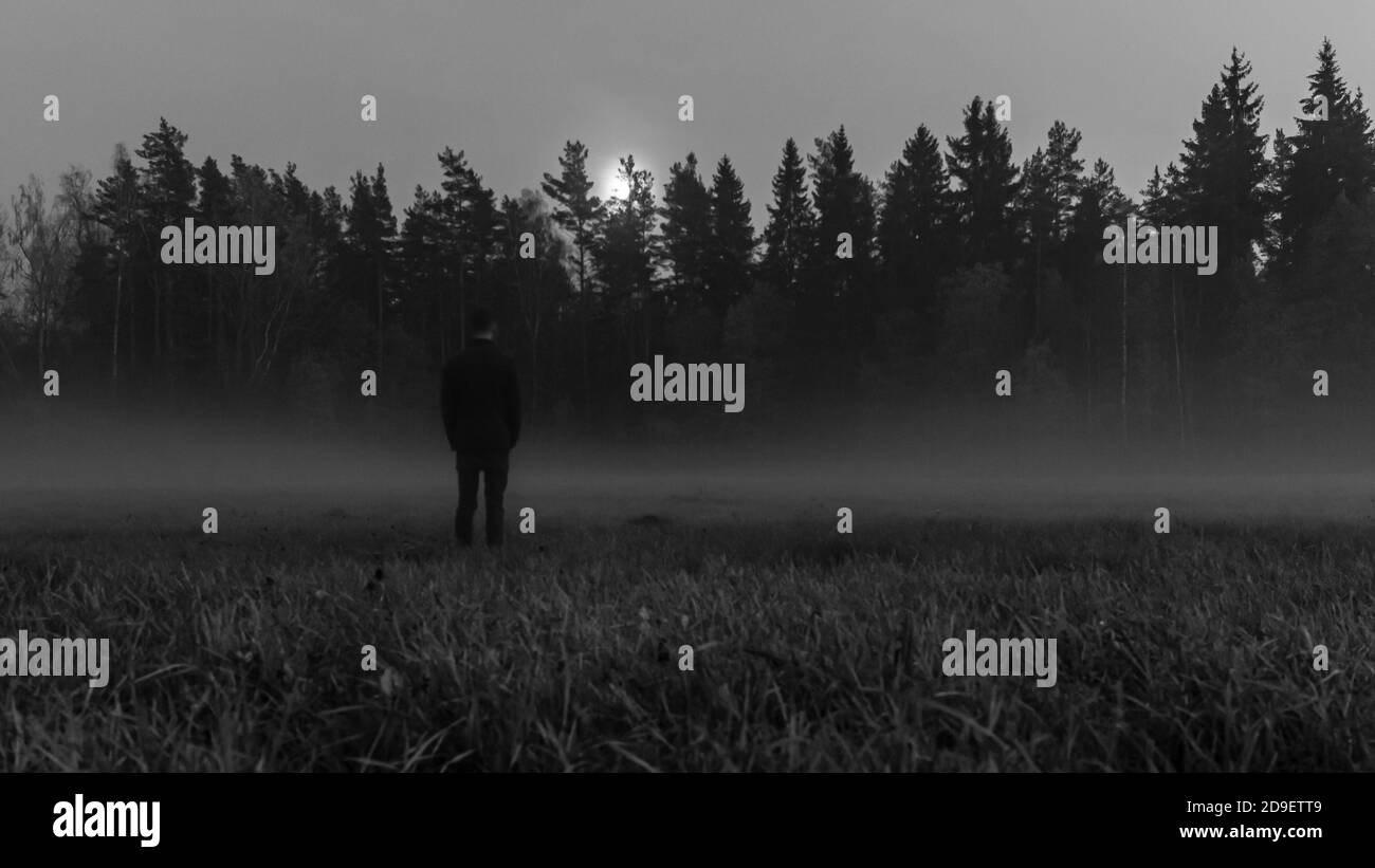 Forêt naturelle prairie noir et blanc image fantôme, hommes silhouette regardant dans la forêt sombre Banque D'Images