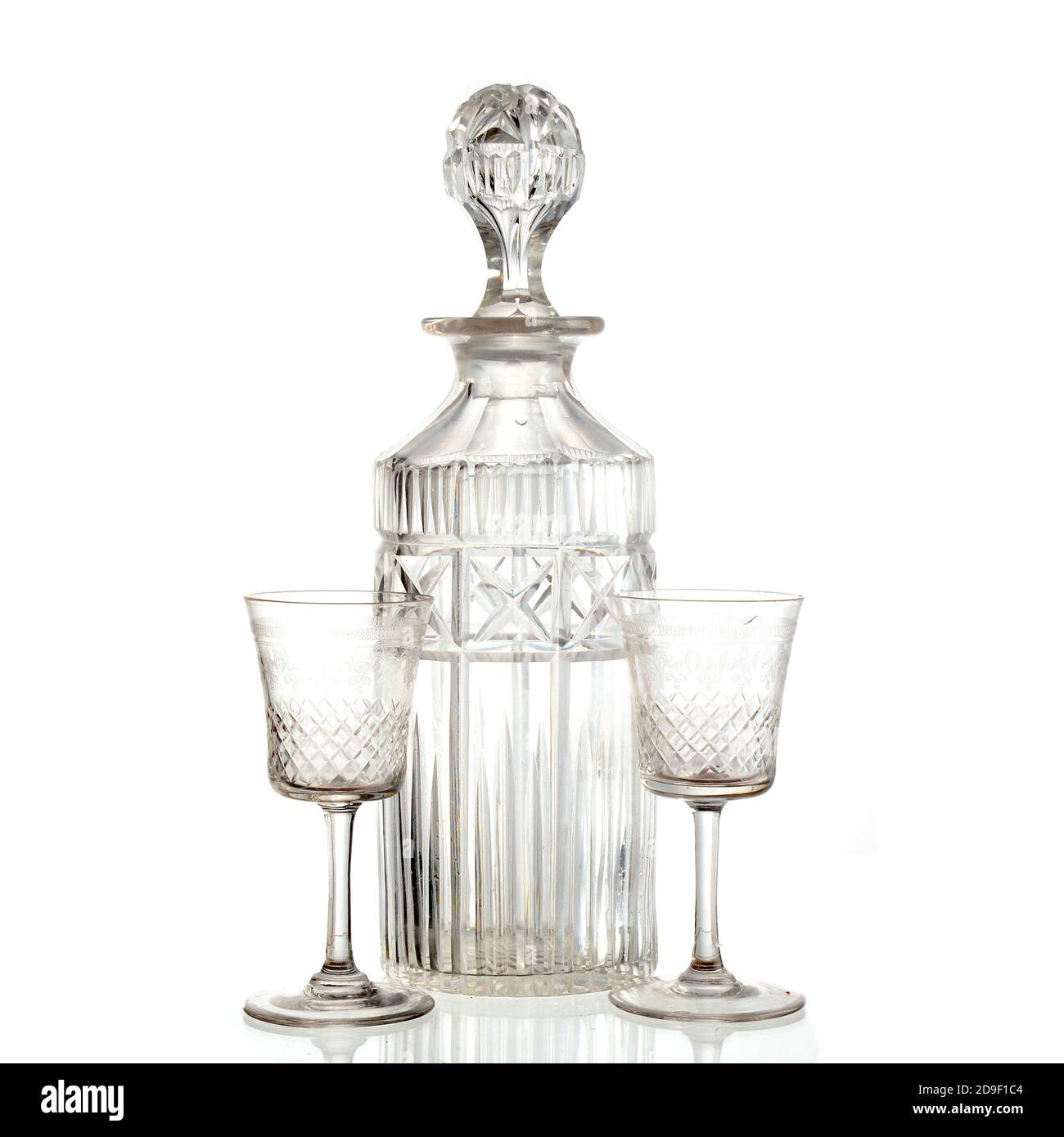Carafe en verre vintage et deux verres en sherry cristal sur fond blanc. Prise de vue en studio Banque D'Images