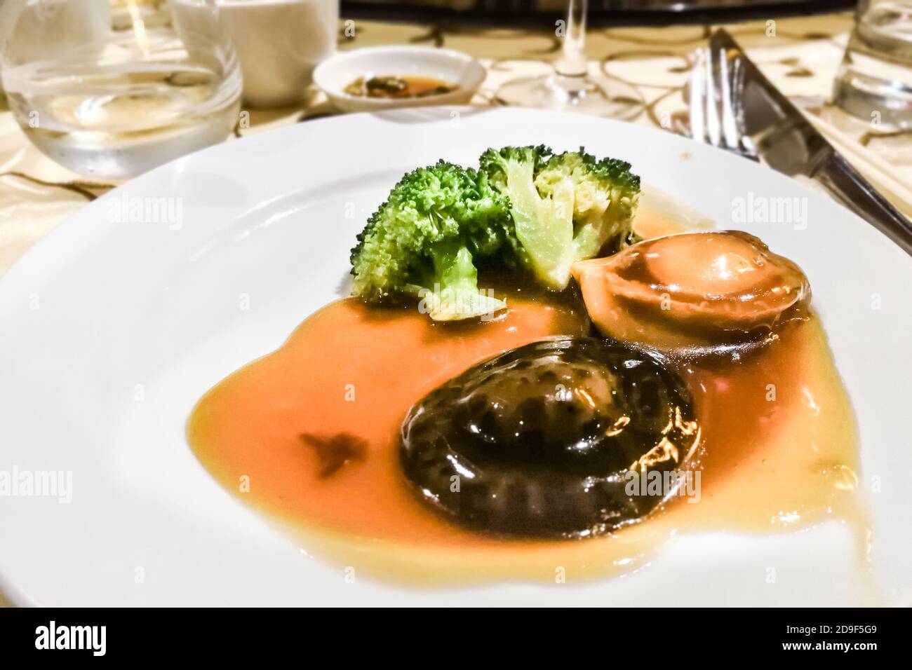 Ormeau braisé avec champignons et brocoli dans une sauce supérieure Banque D'Images