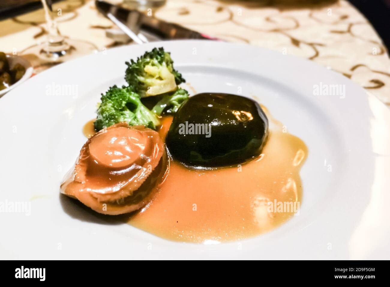 Ormeau braisé avec champignons et brocoli dans une sauce supérieure Banque D'Images