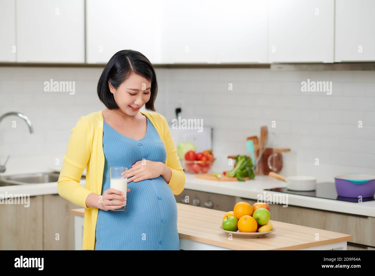 Joyeuse attendant femme dans sa cuisine boire du lait Banque D'Images