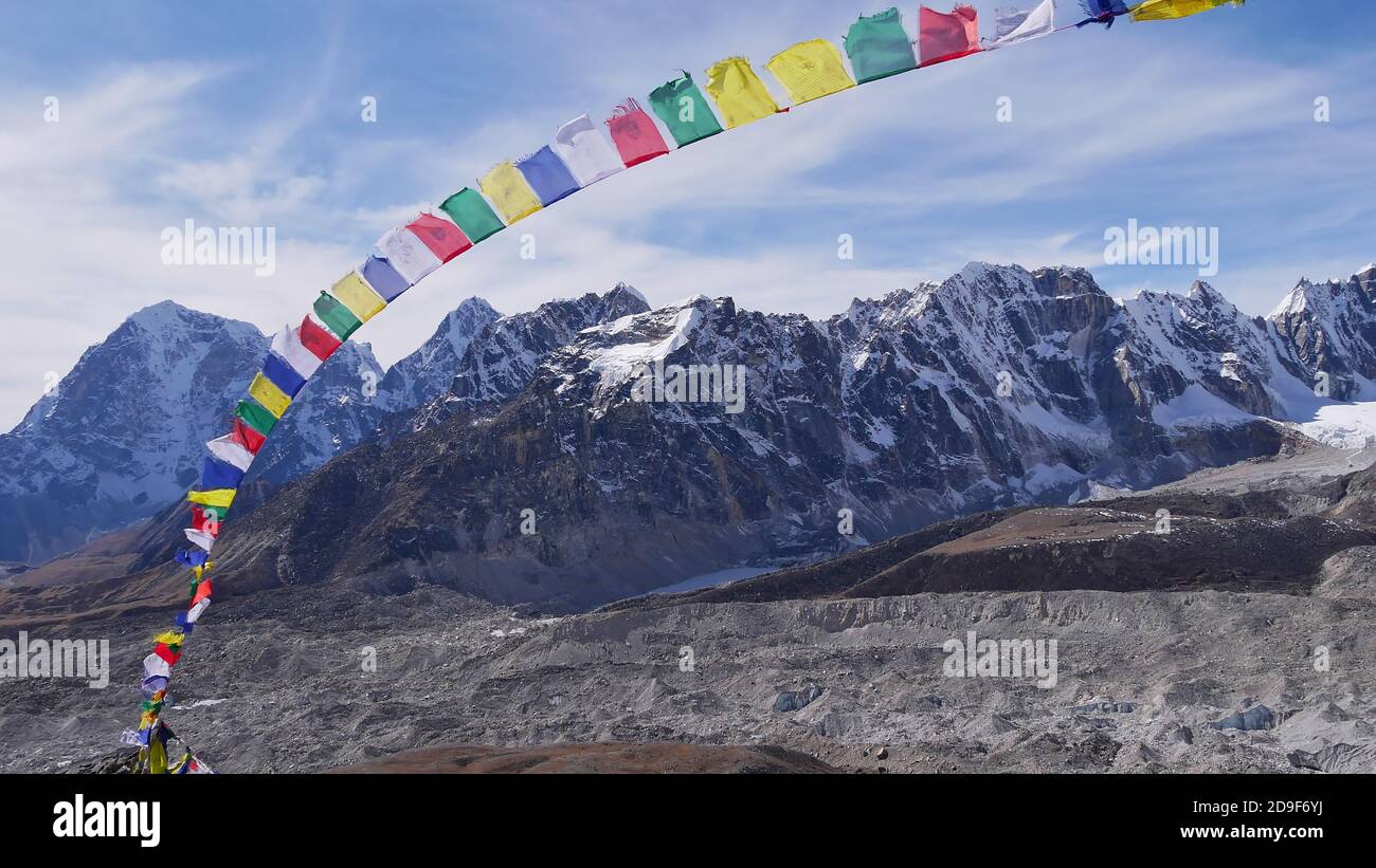 Drapeaux de prière bouddhistes colorés volant dans le vent fort sur le sommet de Kala Patthar, parc national de Sagarmatha, Himalaya, Népal. Banque D'Images