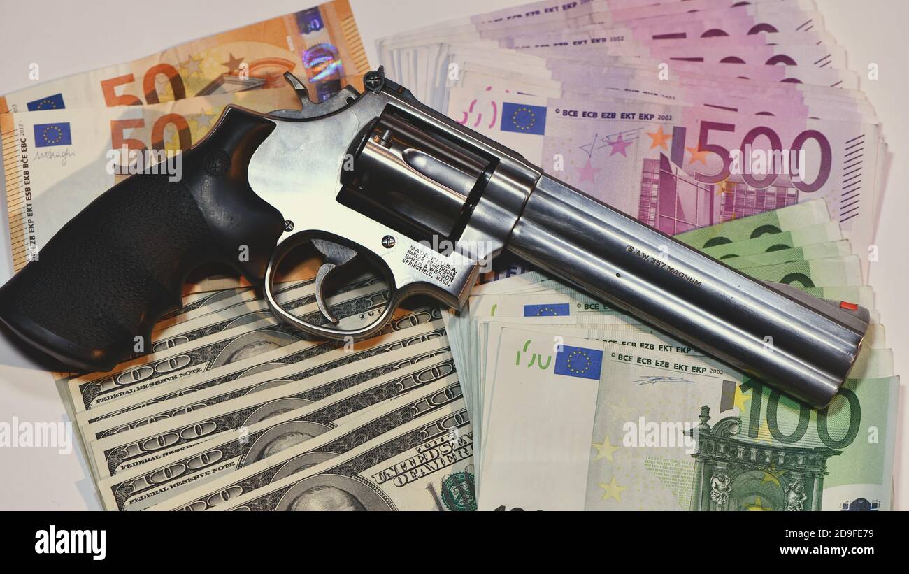 Le revolver Smith e Wesson 357 manum sur fond de billets en euros. Concept de vol, argent sale, crime Banque D'Images