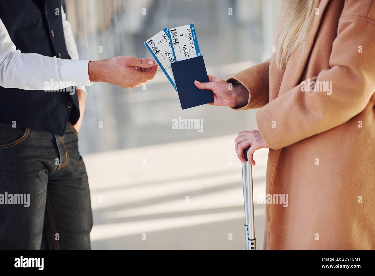 Vue rapprochée d'une femme qui donne des billets pour la sécurité homme à l'aéroport Banque D'Images