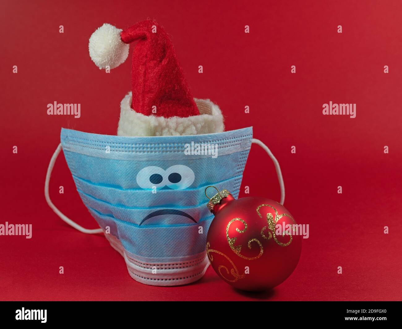 Masque avec chapeau de Père Noël et visage dans un mauvaise humeur Banque D'Images