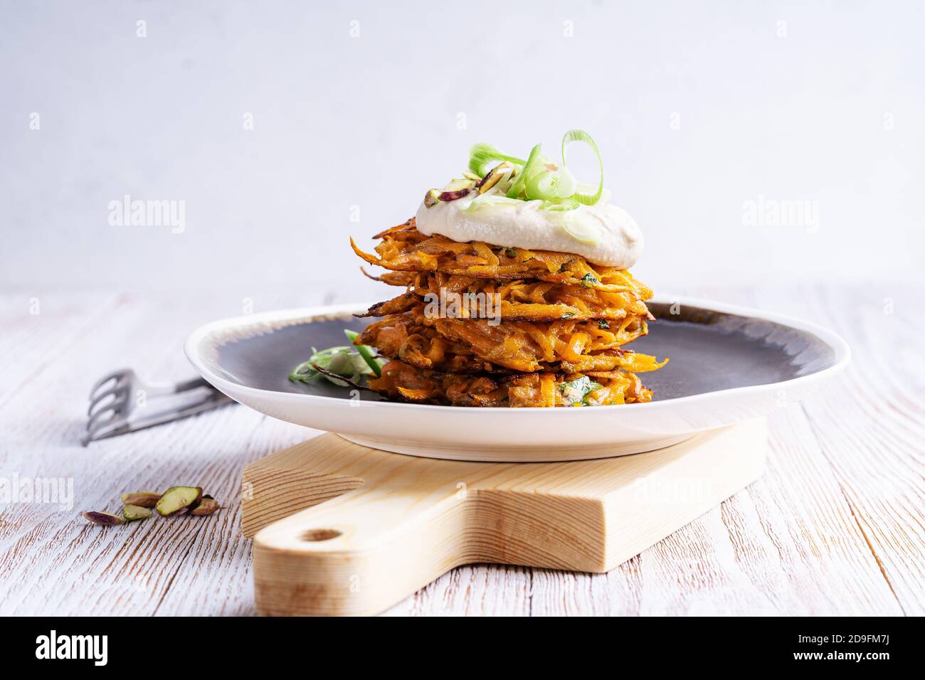 Beignets de pommes de terre avec houmous et pistaches sur table en bois, repas végétalien Banque D'Images