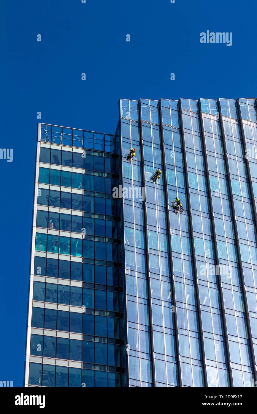 Nettoyeurs de fenêtres descendant d'un gratte-ciel de verre contemporain de nettoyage de fenêtres, Varsovie, Pologne Banque D'Images