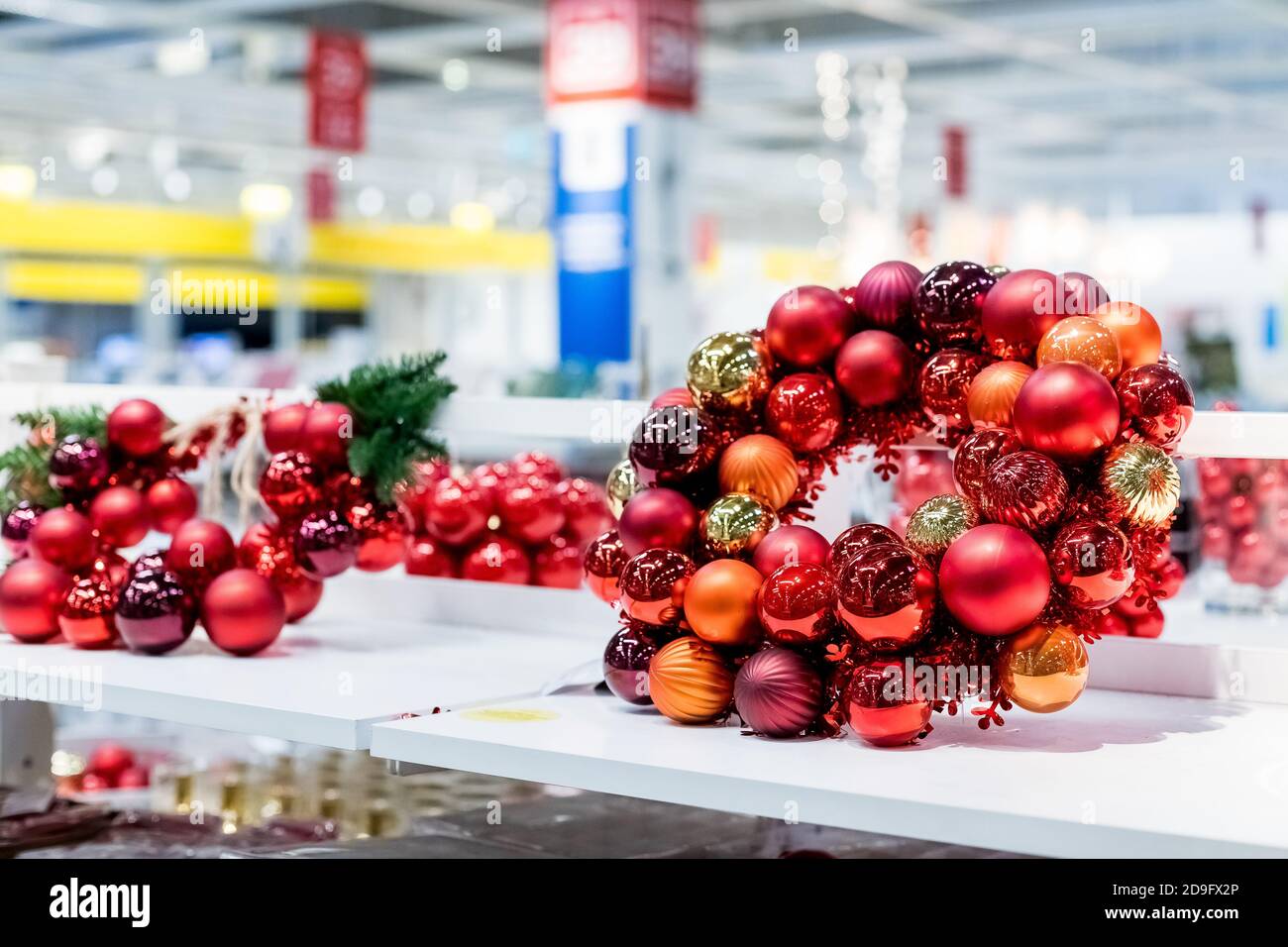 Cadre rond des fêtes, boules de Noël en verre rouge, couronne de noël lumineuse dans la tablette du supermarché. Bonne décoration de nouvel an. Black friday. Décoration d'intérieur Banque D'Images