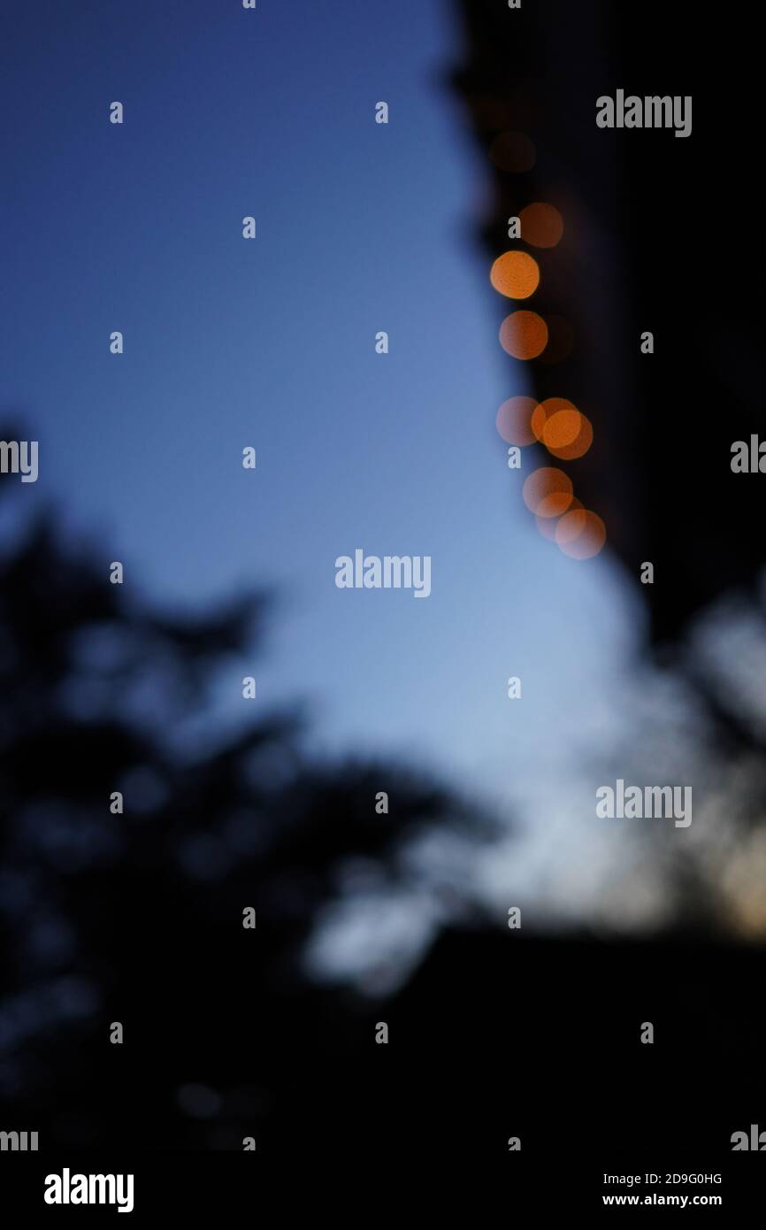 Arrière-plan flou créatif pour noël. Boules orange floues contre bleu ciel de nuit. Banque D'Images