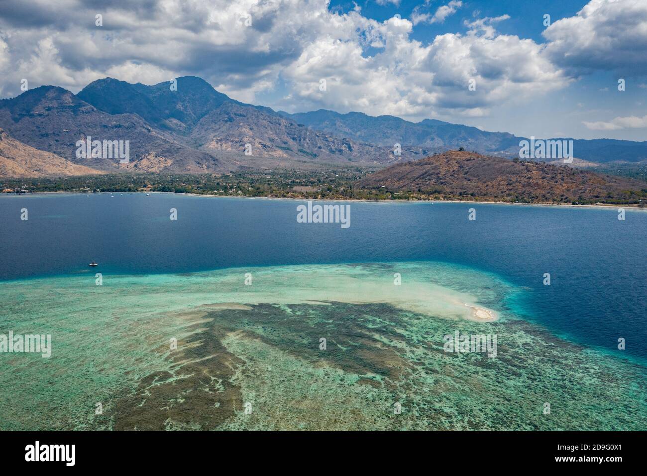 île de sable et récif de corail dans l'eau bleue océan avec île de montagne Banque D'Images