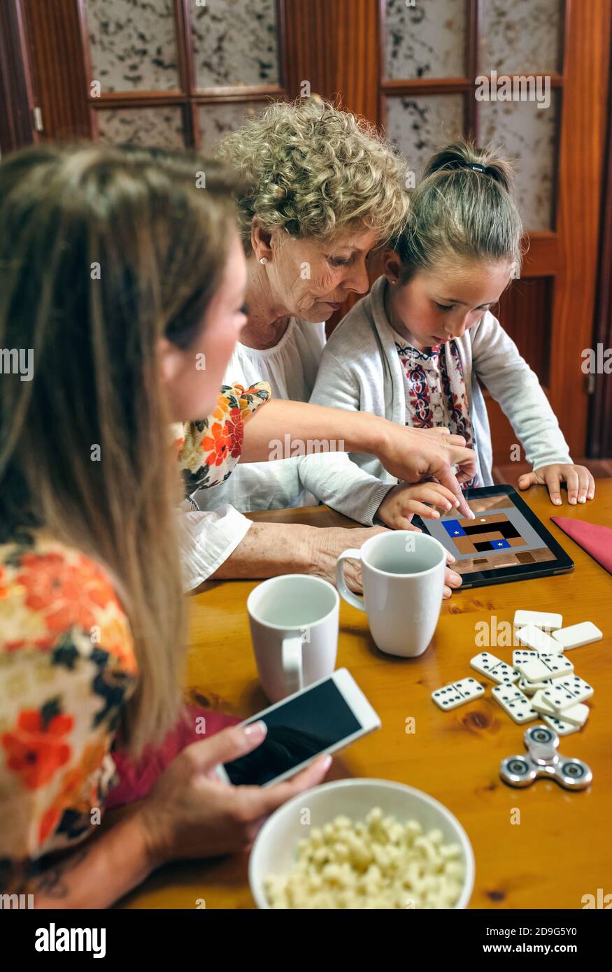 Grand-mère et petite-fille jouent à un jeu sur la tablette Banque D'Images