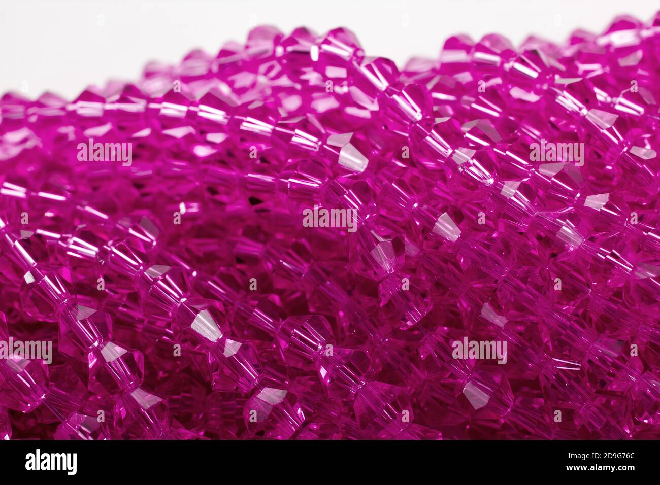 Magnifiques perles isolantes en verre rose étincelant sur fond blanc. À utiliser pour les bijoux à perles de bricolage. Espace pour le texte Banque D'Images