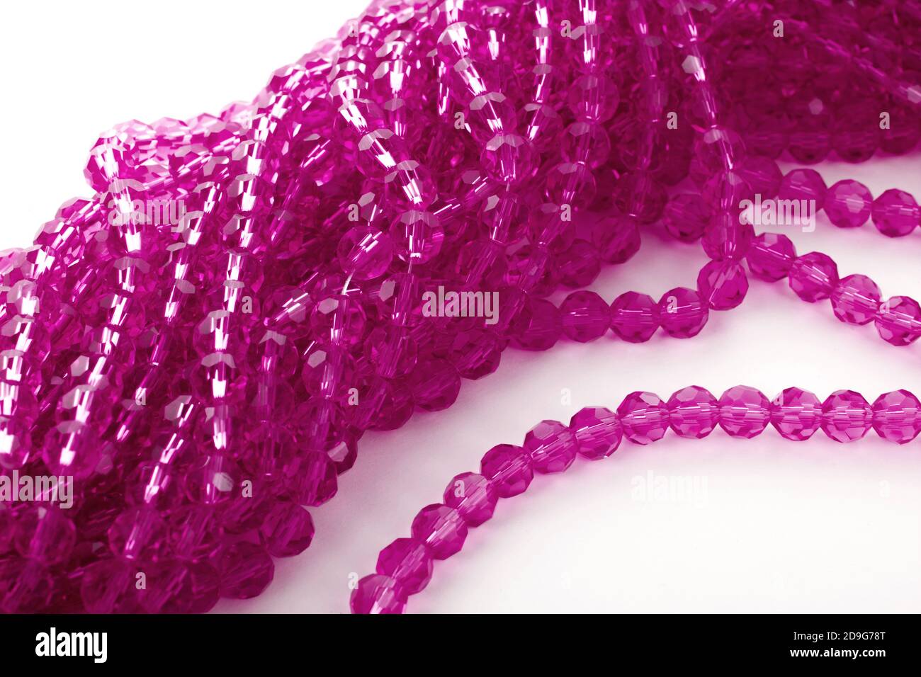 Magnifiques perles isolantes en verre rose étincelant sur fond blanc. À utiliser pour les bijoux à perles de bricolage. Espace pour le texte Banque D'Images