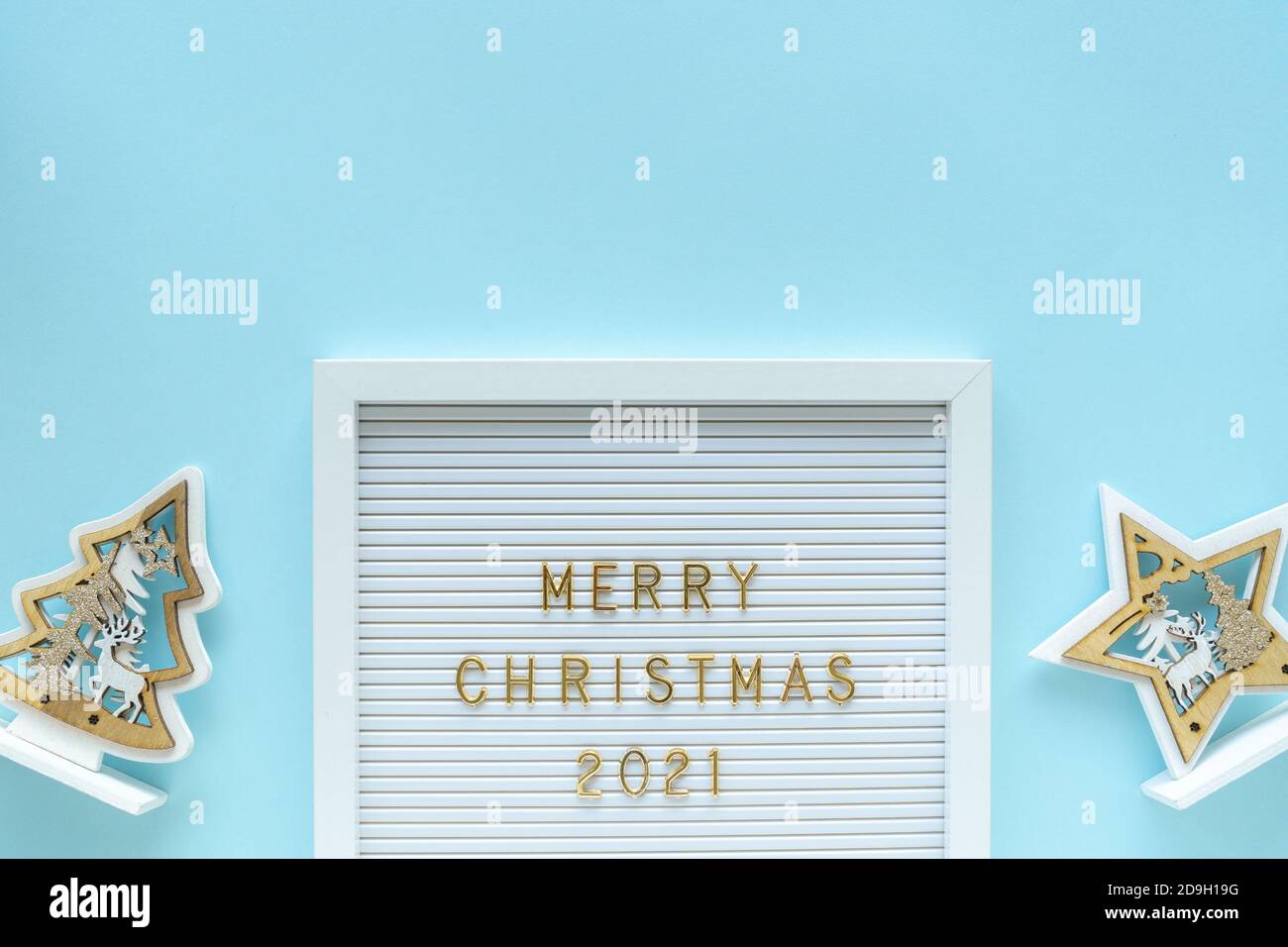 Tableau de lettres avec message d'accueil Merry Christmas 2021, décorations sur fond bleu pastel girly. Composition de Noël. Pose à plat, par le dessus Banque D'Images
