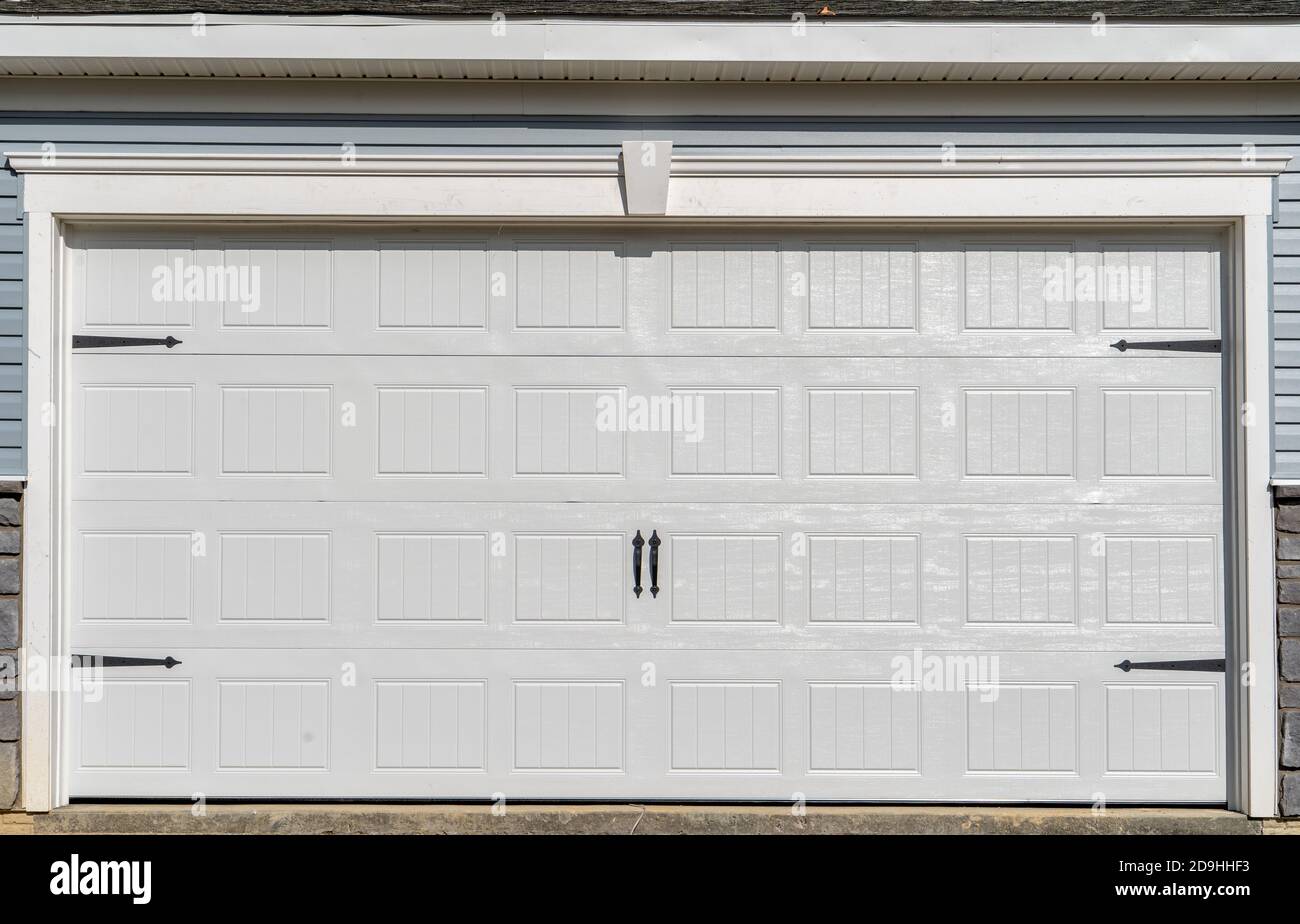 Double voiture classique isolée en acier à panneaux surélevés porte de garage encadrée avec une garniture blanche pour ajouter de l'accent, sur une nouvelle maison américaine Banque D'Images