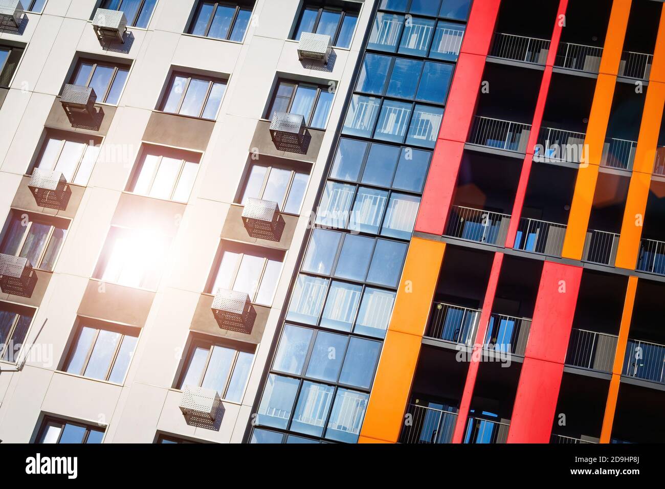 Façade de bâtiment avec balcon et climatisation. Lumière du soleil reflétée dans la fenêtre, vue en angle. Banque D'Images