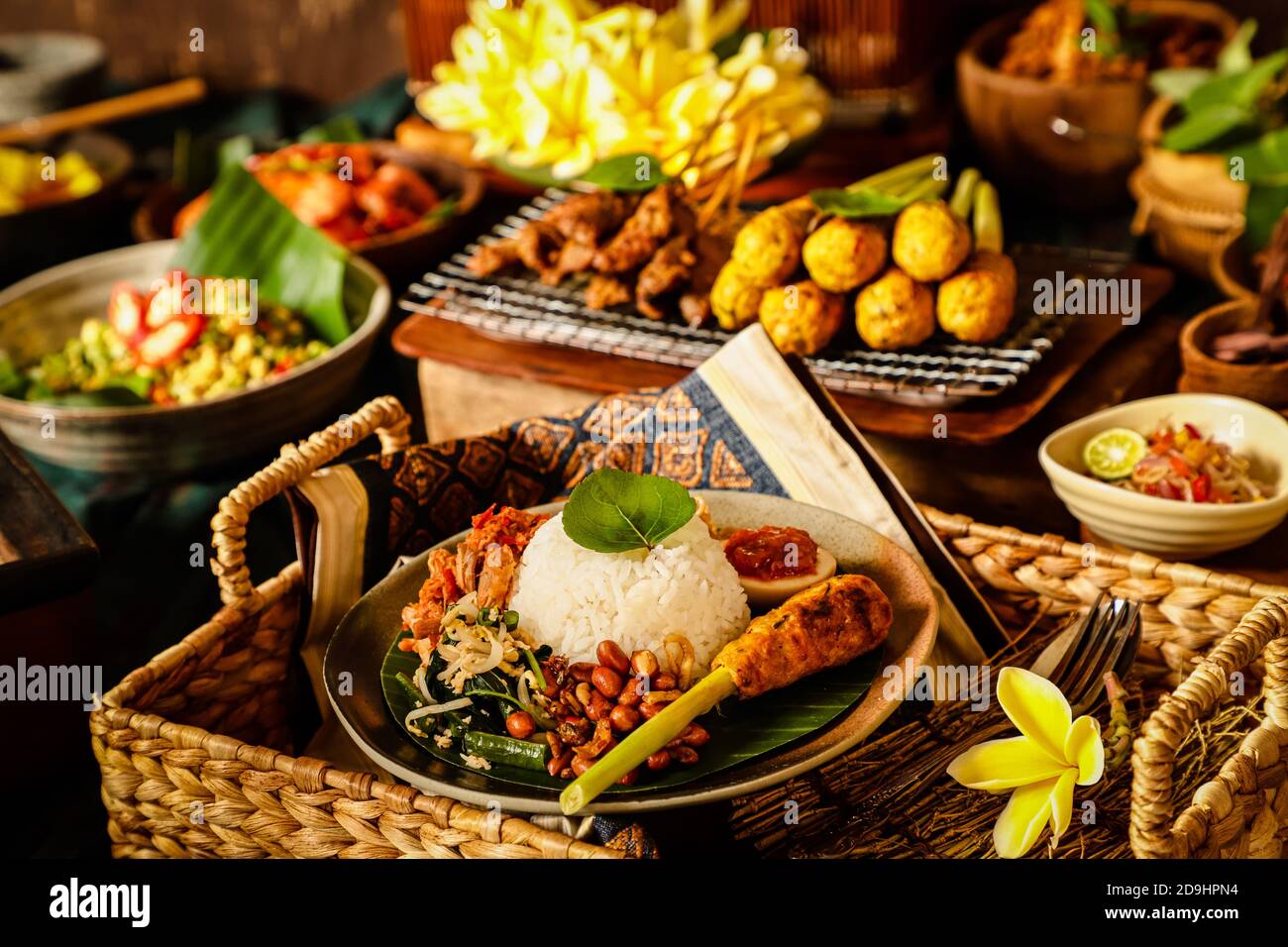 Nasi Campur Bali. Repas balinais de riz avec poulet râpé, salade de légumes, arachides, satay, œuf et nouilles frites. Banque D'Images