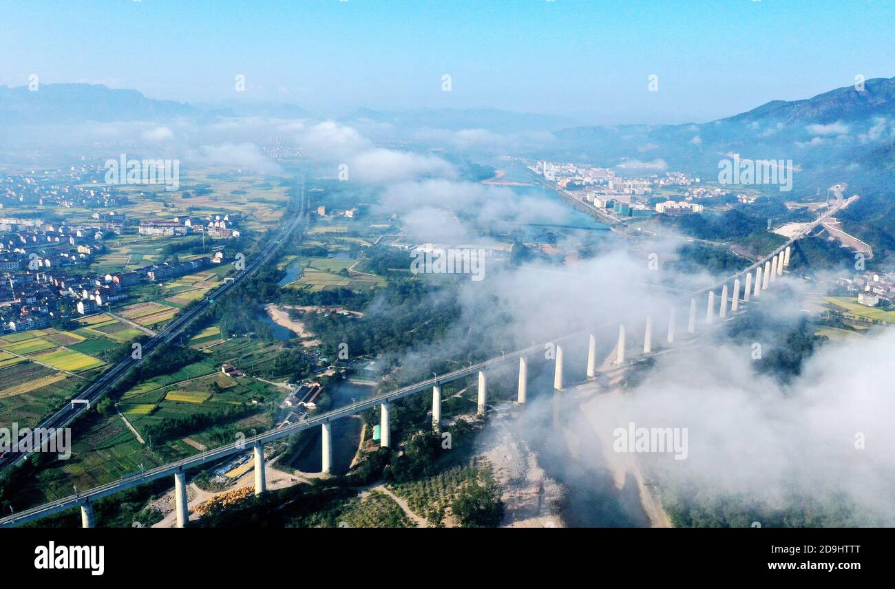 Une vue aérienne d'une partie d'un chemin de fer aérien à travers les cours d'eau et partiellement cachée dans les nuages, comté de Xianju, ville de Taizhou, est de la Chine¯s Zhejiang c Banque D'Images