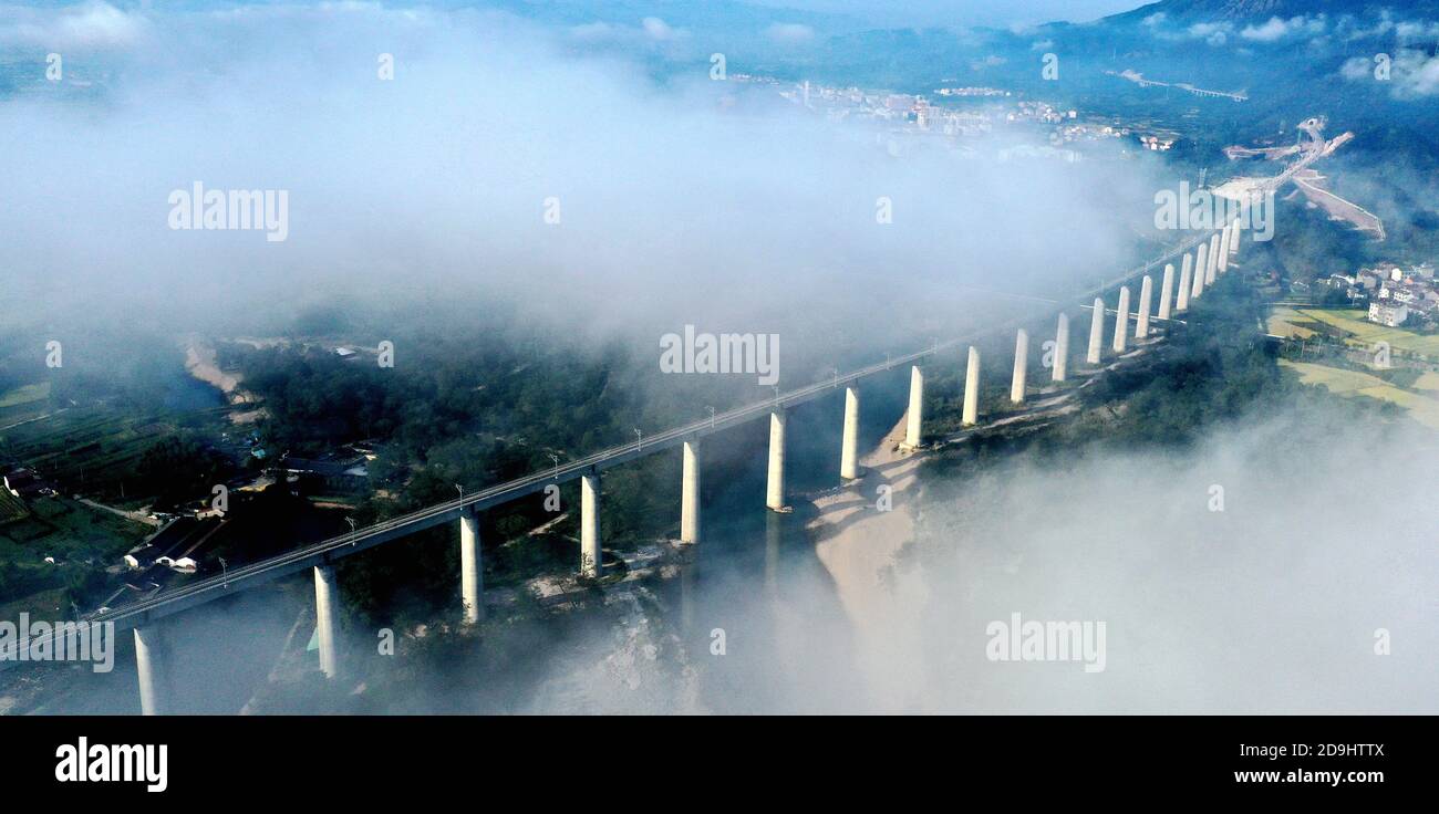 Une vue aérienne d'une partie d'un chemin de fer aérien à travers les cours d'eau et partiellement cachée dans les nuages, comté de Xianju, ville de Taizhou, est de la Chine¯s Zhejiang c Banque D'Images