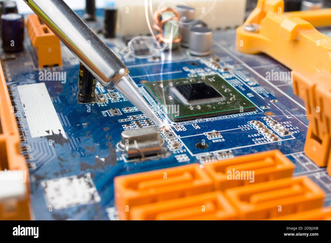 Utilisez un fer à souder pour souder la pièce électronique sur la carte. Réparation de l'ordinateur. Macrophotographie. Banque D'Images
