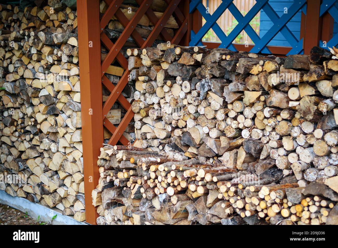 Le bois de chauffage de diverses espèces d'arbres est stocké dans le hangar à bois. Concept de vie de pays. Banque D'Images