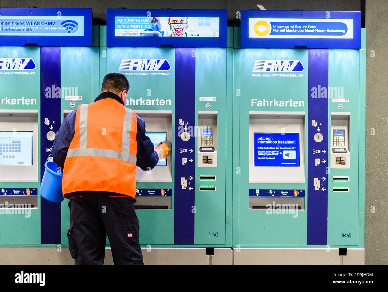 06 novembre 2020, Hessen, Francfort-sur-le-main: Un employé de service nettoie un distributeur de billets Rhein-main-Verkehrsverbund (RMV) dans la gare centrale. Le directeur général du Rhein-main-Verkehrsverbund (RMV) s'attend à une perte de chiffre d'affaires d'environ 250 millions d'euros cette année à la suite de la pandémie de Corona. Photo: Andreas Arnold/dpa Banque D'Images