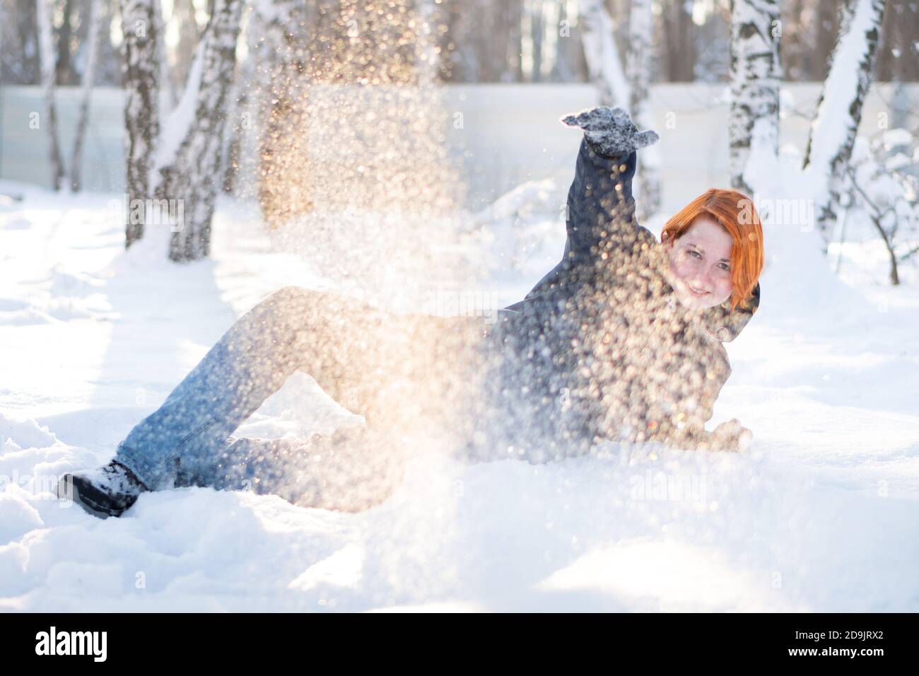 Jolie fille invite à jouer boules de neige se trouve sur la neige dans la forêt. Liberté et concept joyeux. Femme entourée de flocons de neige. Banque D'Images