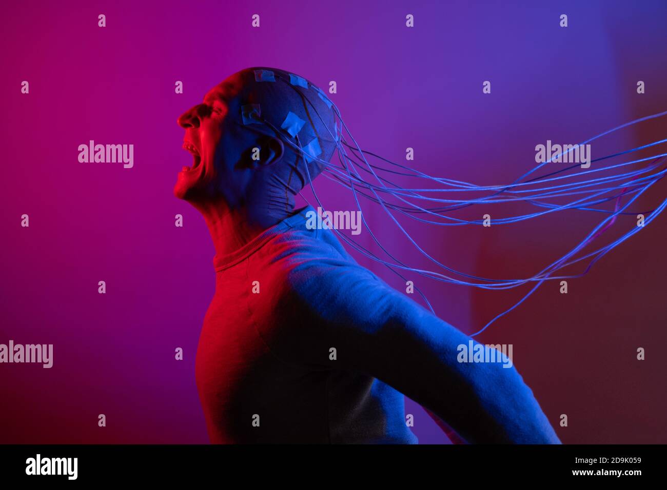 Homme avec des électrodes dans sa tête hurle dans l'horreur, un test de détecteur de mensonge polygraphe, effacement de mémoire. Banque D'Images