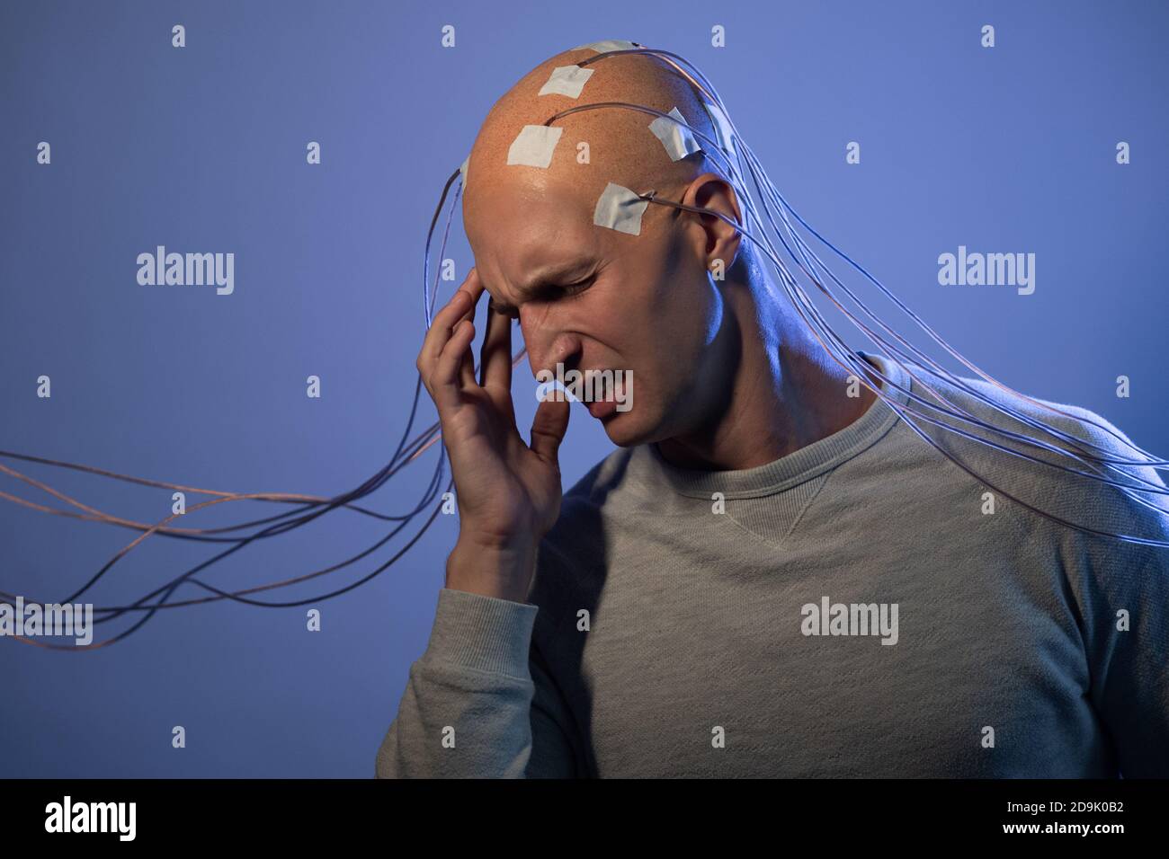 Homme à tête chauve avec fils connectés. Peur et anxiété. Examen du cerveau, contrôle mental. Banque D'Images