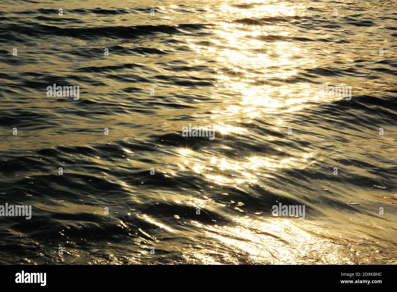 Magnifique mer éclatante à l'aube. Vagues dorées et rayons de soleil en mer. Magnifique paysage marin. Banque D'Images