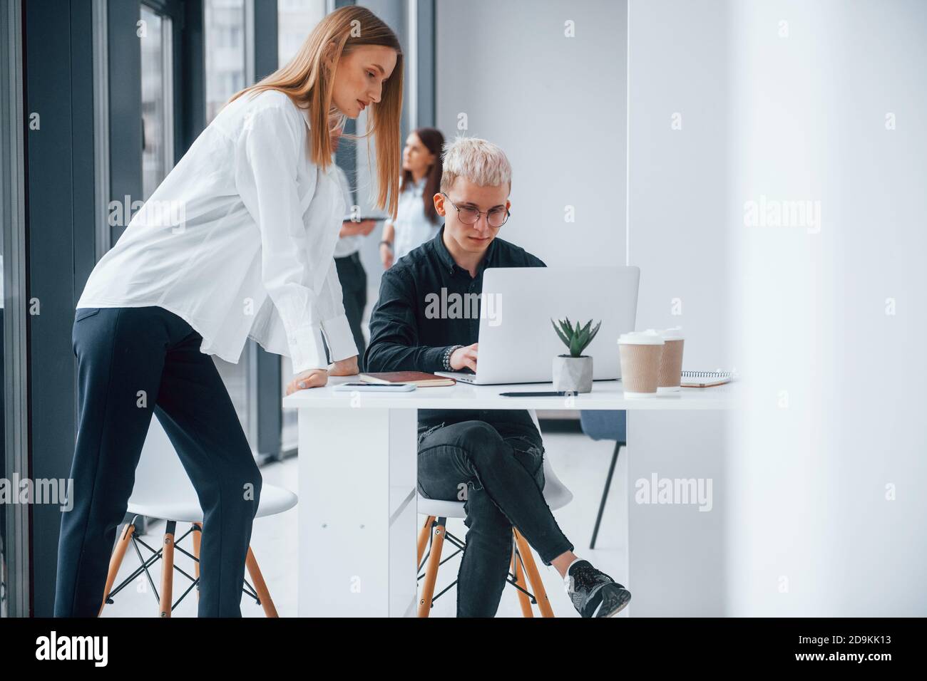 Femme et hipster homme devant le groupe de jeunes une équipe réussie qui travaille et communique ensemble à l'intérieur du bureau Banque D'Images