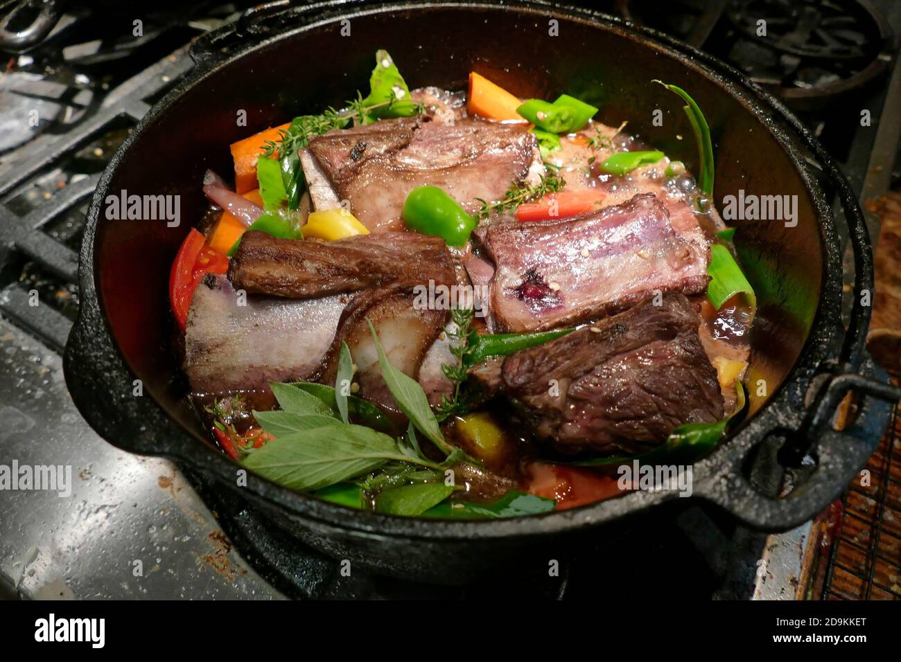 Côtelettes de bœuf braisé aux poivrons frais, carottes et tomates dans un four hollandais en fonte, dans une cuisine de Seattle, Washington Banque D'Images