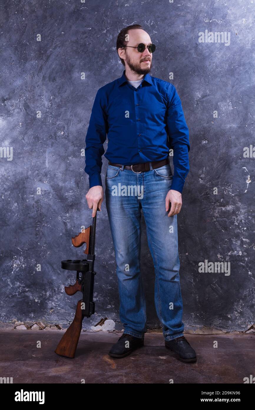 Homme mature en lunettes de soleil avec tommy Gun studio portrait Banque D'Images