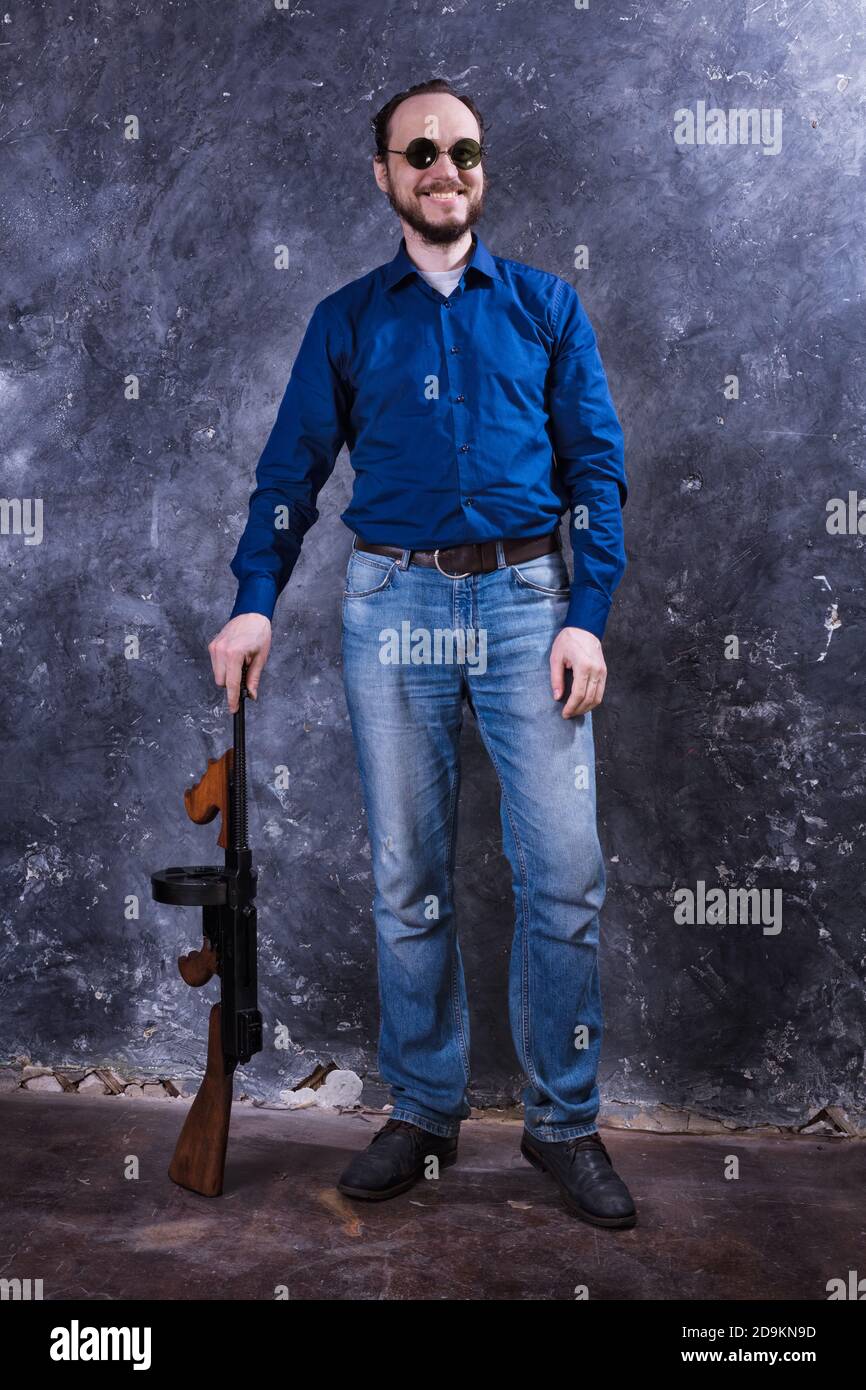 Homme mature en lunettes de soleil avec tommy Gun studio portrait Banque D'Images