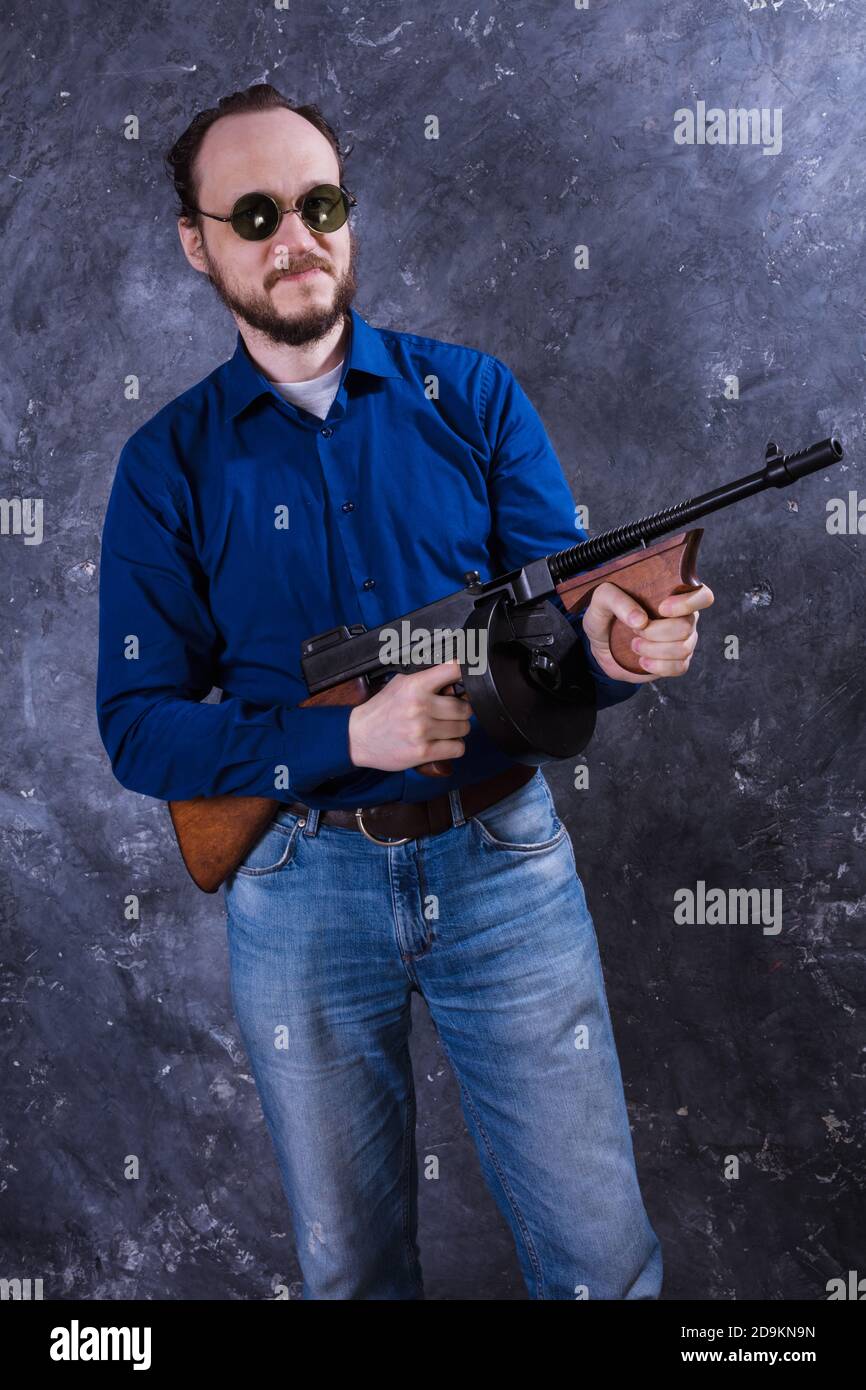 Homme mature en lunettes de soleil avec tommy Gun studio portrait Banque D'Images