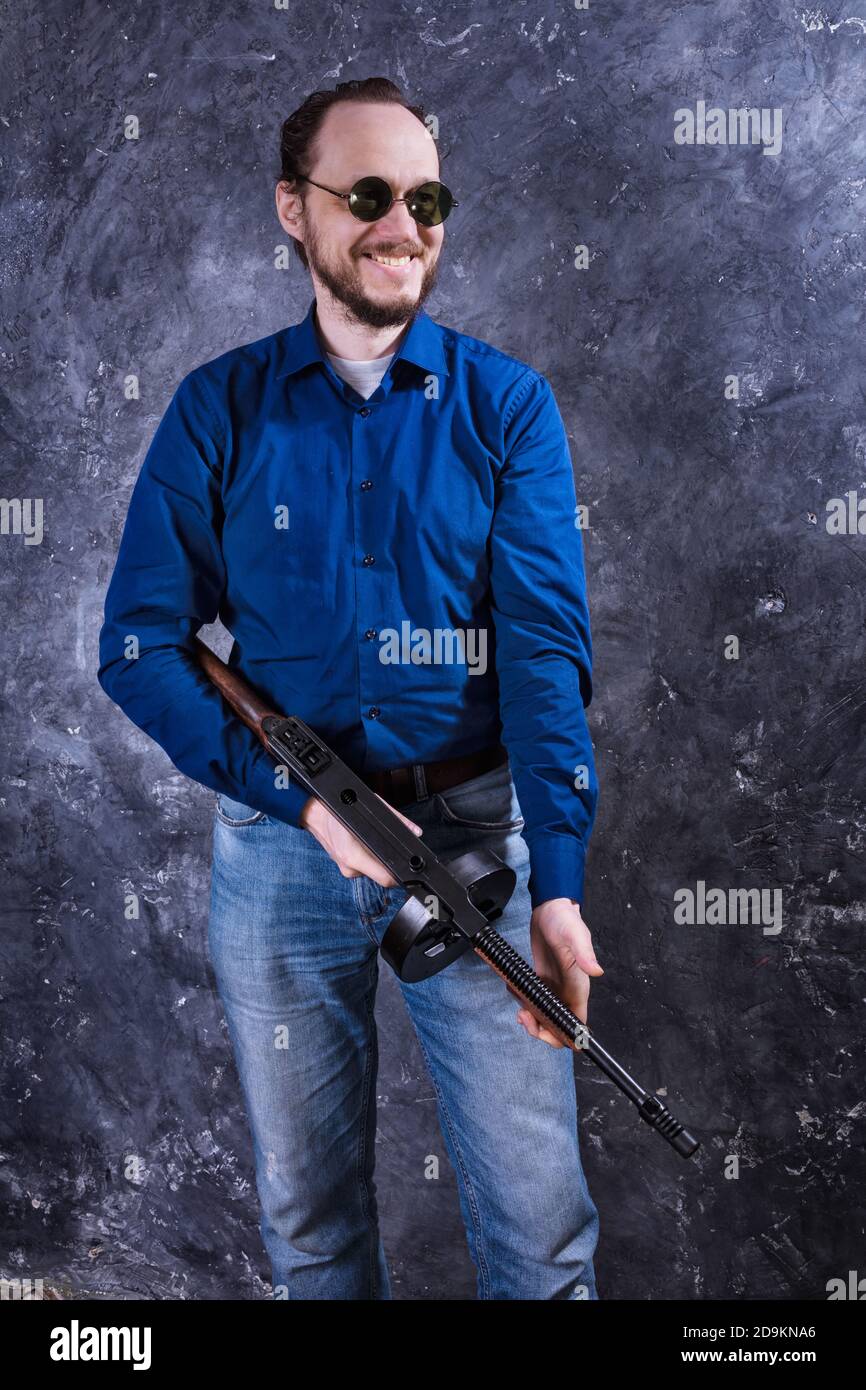 Homme mature en lunettes de soleil avec tommy Gun studio portrait Banque D'Images