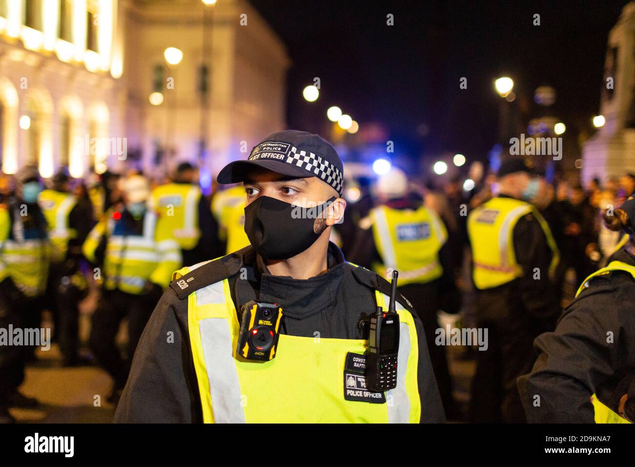 Portrait d'un officier de police debout devant une bouilloire pendant la marche million Mask à laquelle ont assisté de nombreux sceptiques de verrouillage, Oxford Street, Londres, 5 Banque D'Images