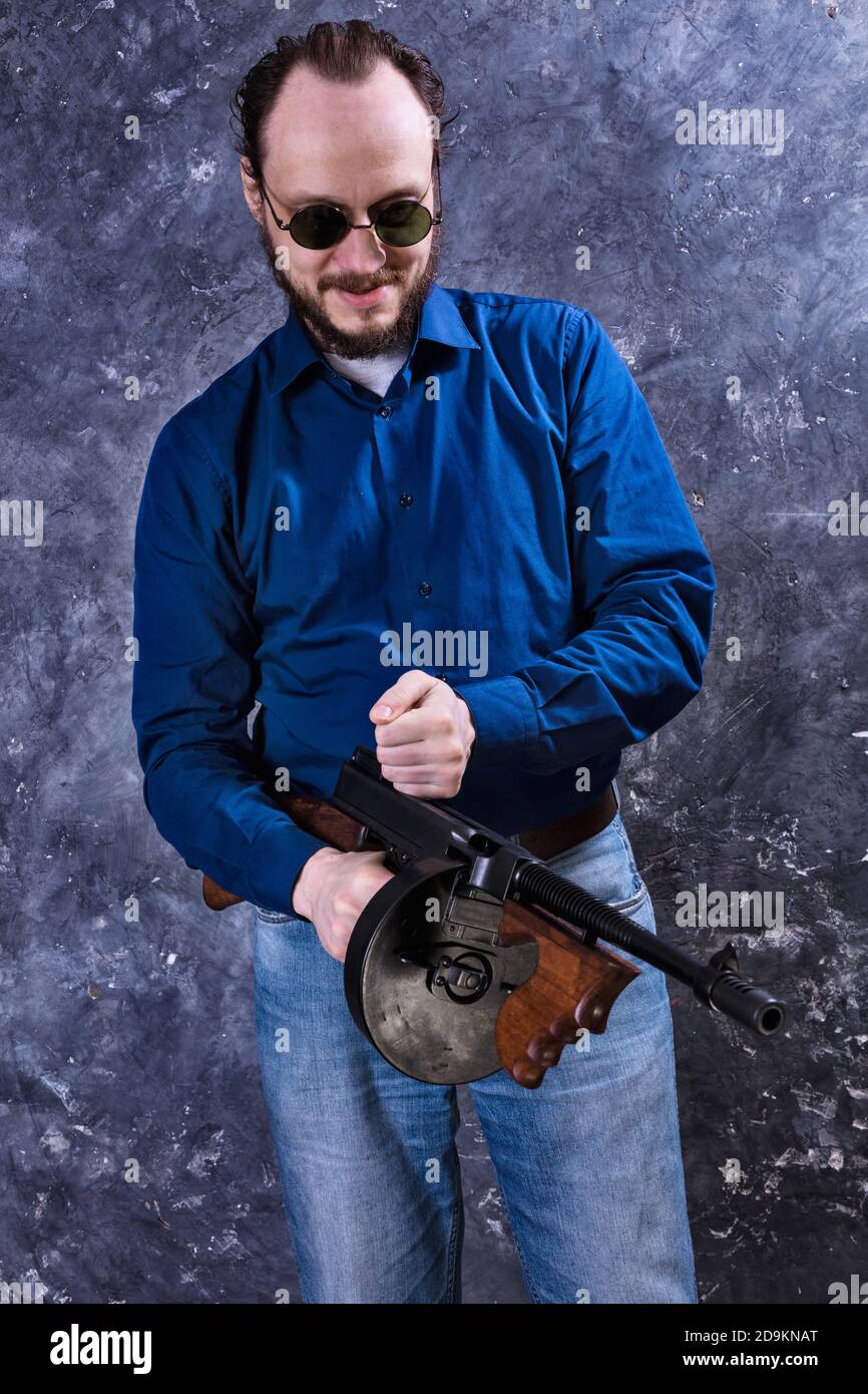 Homme mature en lunettes de soleil avec tommy Gun studio portrait Banque D'Images