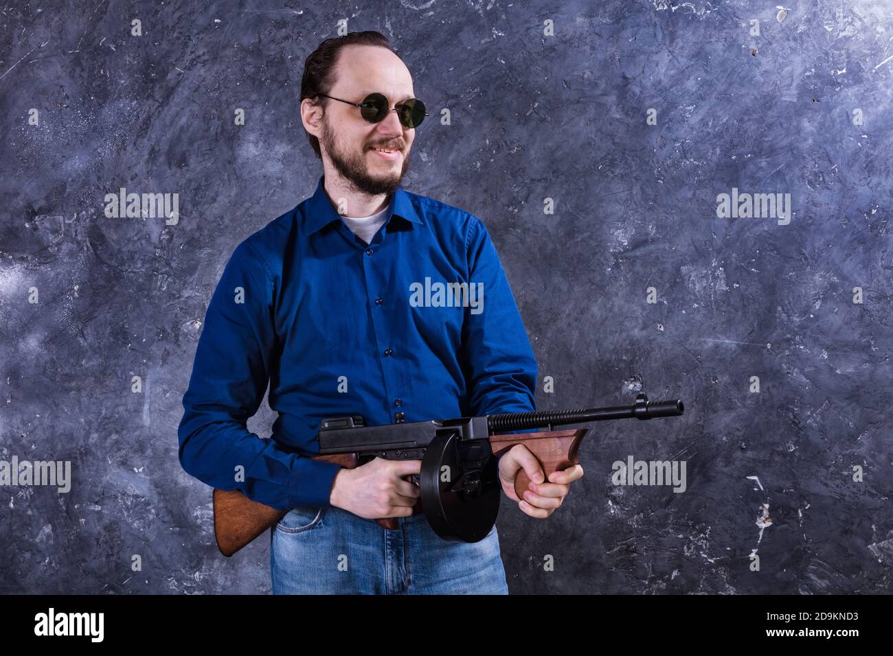 Homme mature en lunettes de soleil avec tommy Gun studio portrait Banque D'Images