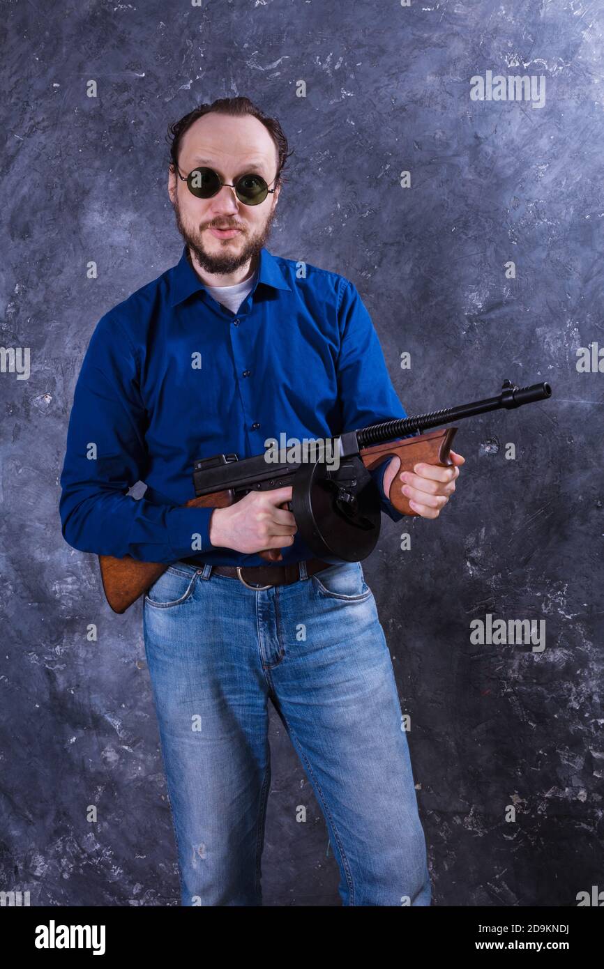 Homme mature en lunettes de soleil avec tommy Gun studio portrait Banque D'Images