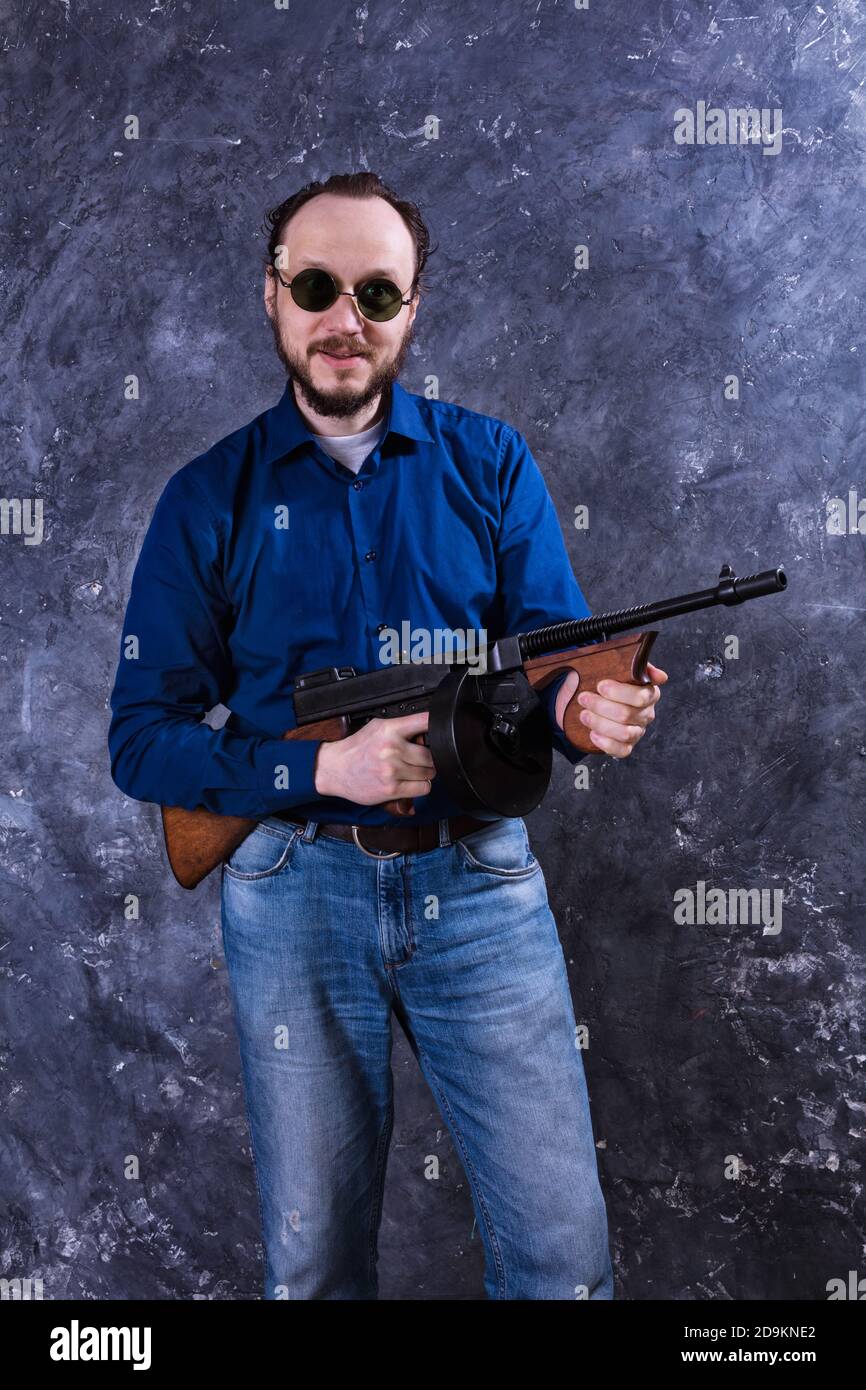 Homme mature en lunettes de soleil avec tommy Gun studio portrait Banque D'Images
