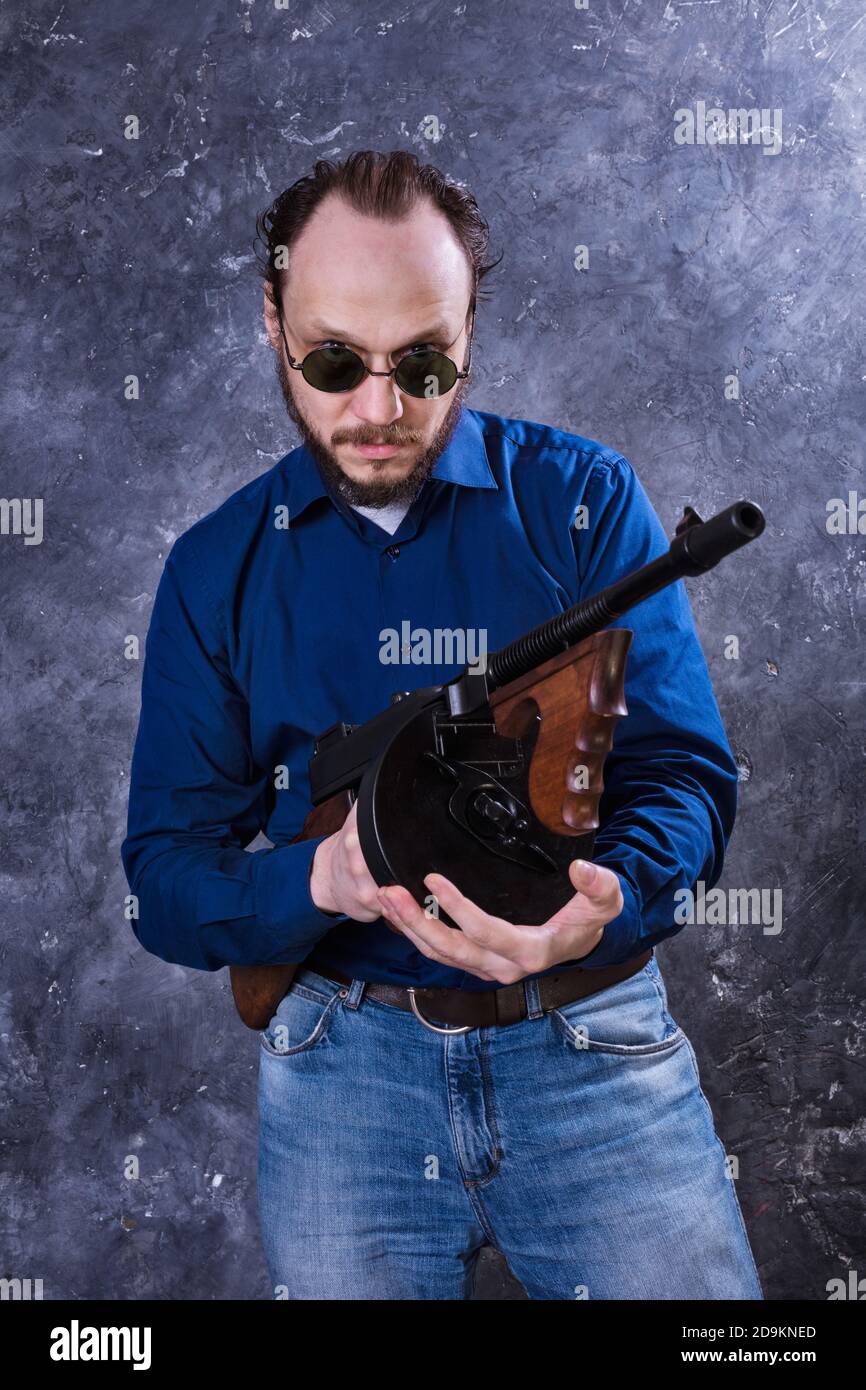 Homme mature en lunettes de soleil avec tommy Gun studio portrait Banque D'Images