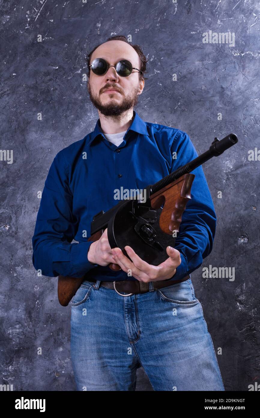 Homme mature en lunettes de soleil avec tommy Gun studio portrait Banque D'Images