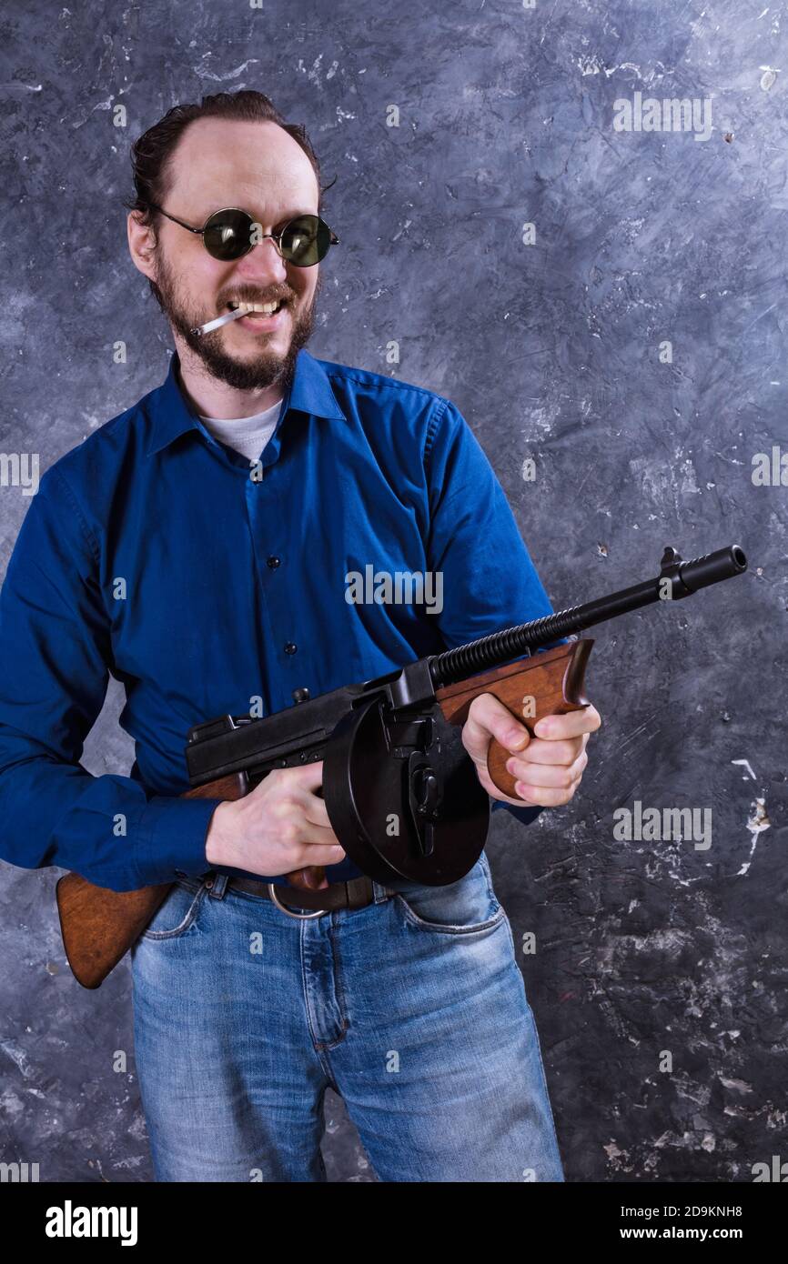 Homme mature en lunettes de soleil avec tommy Gun studio portrait Banque D'Images