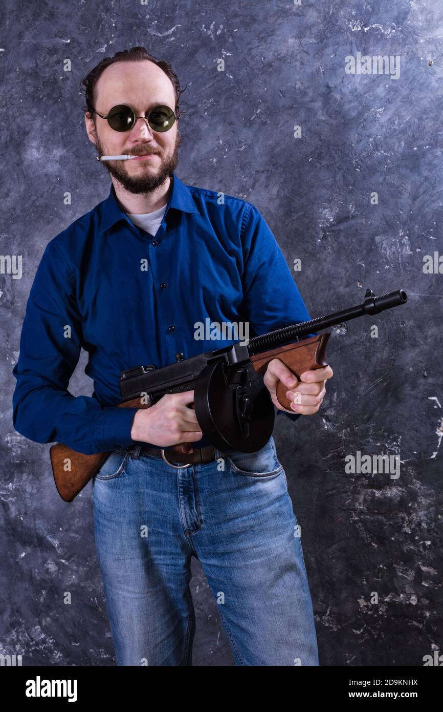 Homme mature en lunettes de soleil avec tommy Gun studio portrait Banque D'Images
