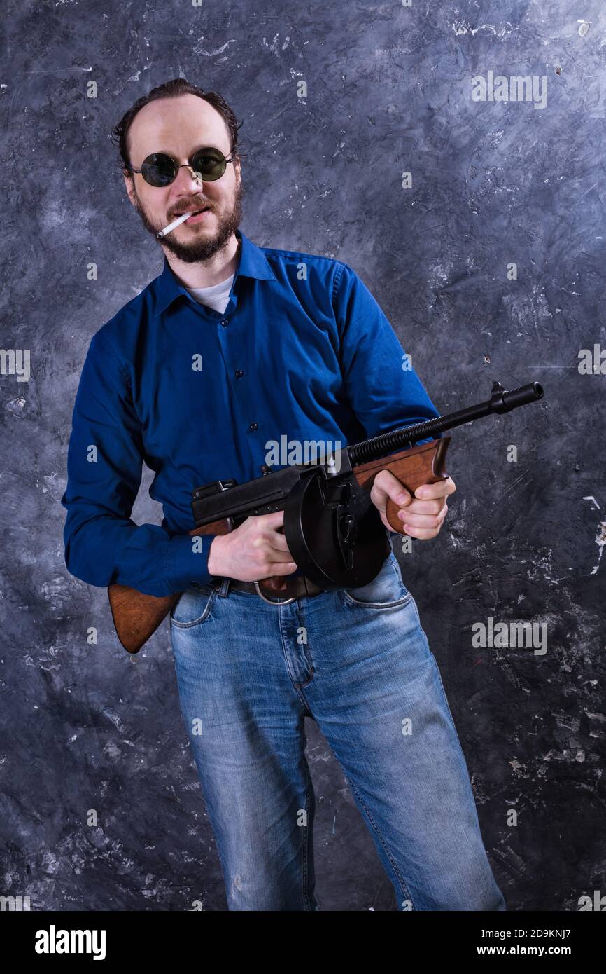 Homme mature en lunettes de soleil avec tommy Gun studio portrait Banque D'Images