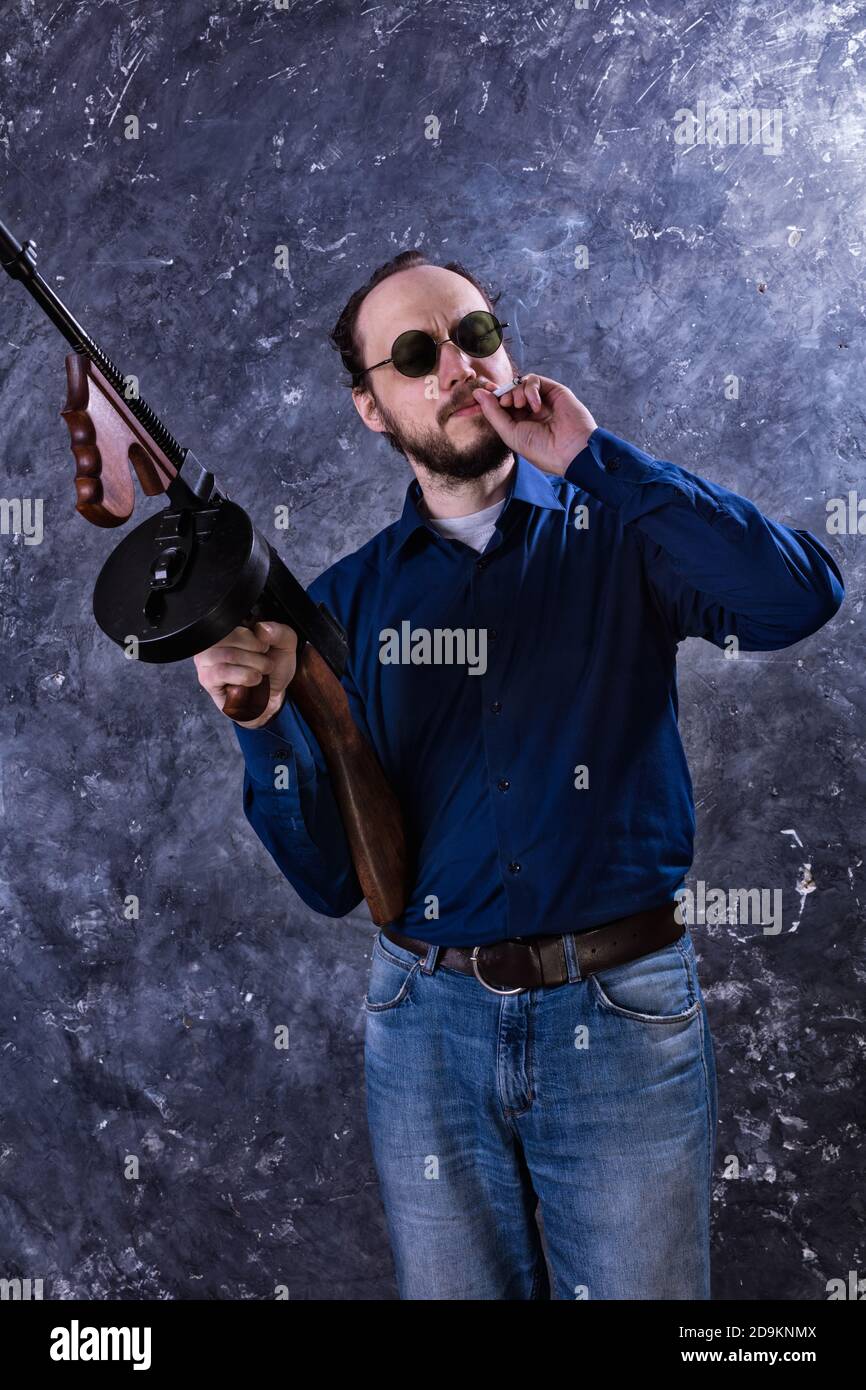 Homme mature en lunettes de soleil avec tommy Gun studio portrait Banque D'Images