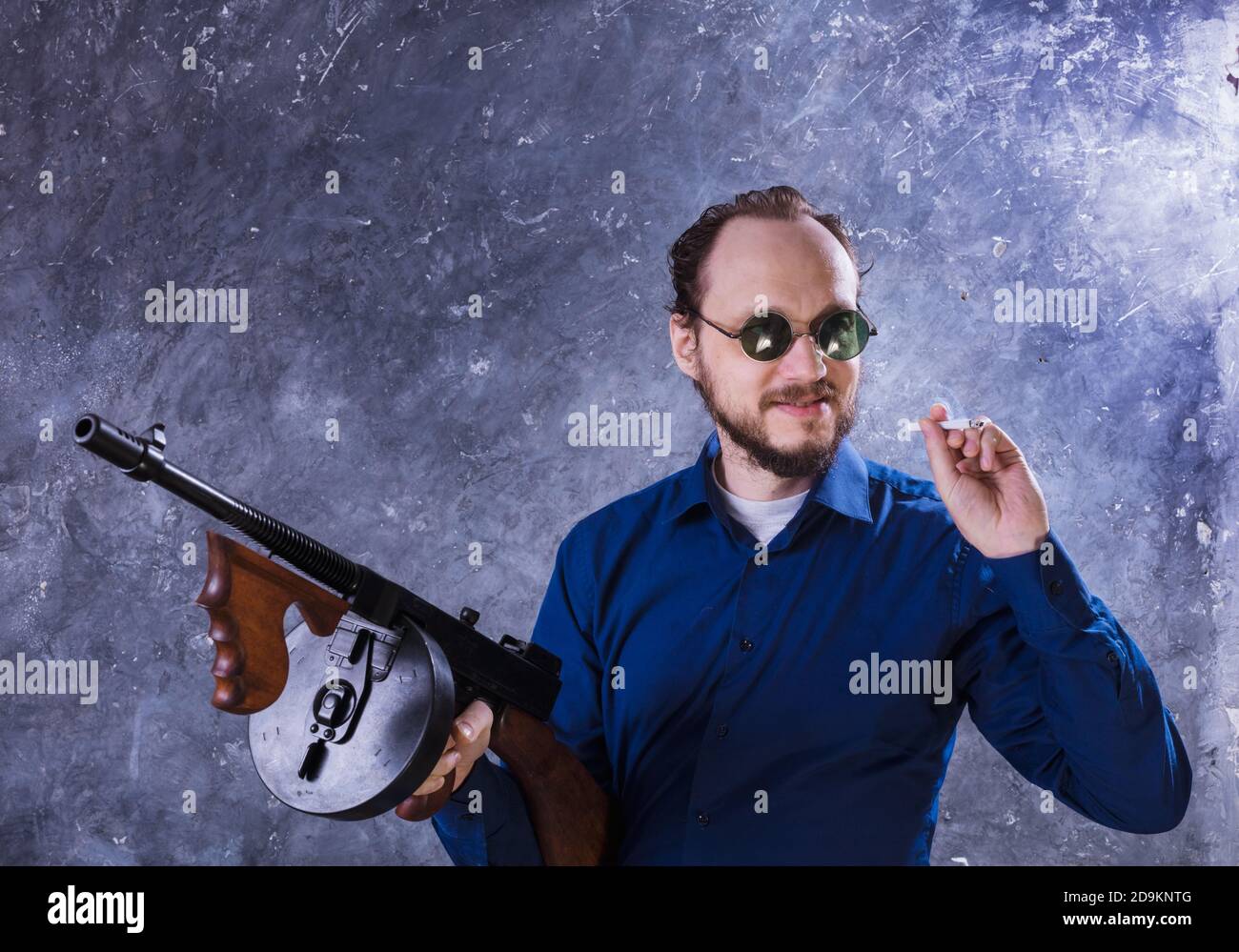Homme mature en lunettes de soleil avec tommy Gun studio portrait Banque D'Images