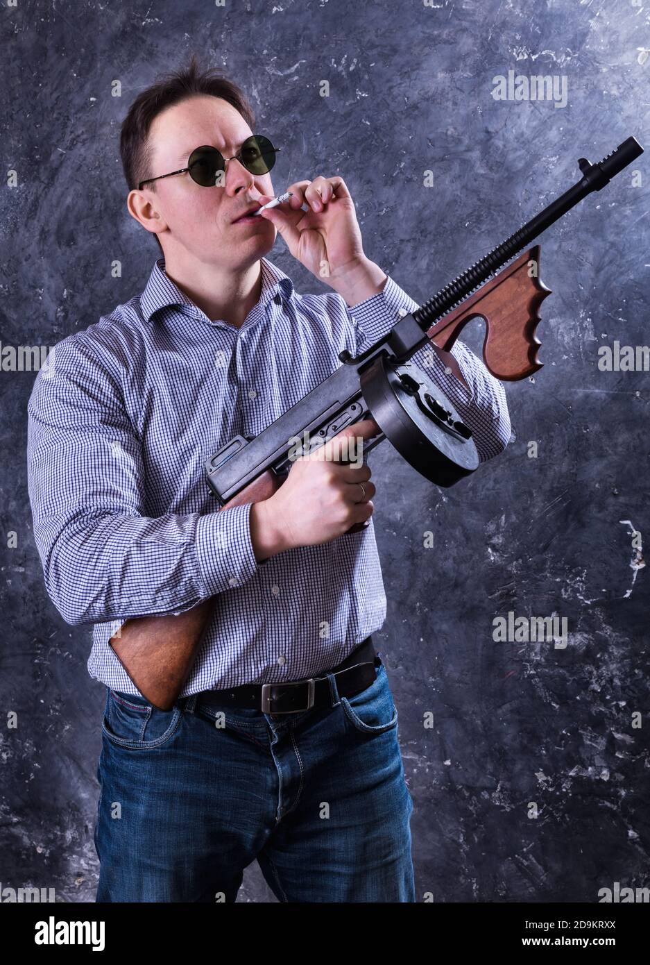 Homme mature en lunettes de soleil avec tommy Gun studio portrait Banque D'Images