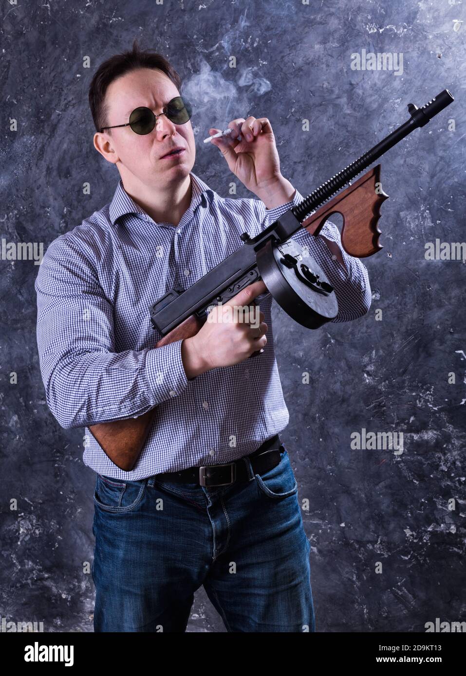 Homme mature en lunettes de soleil avec tommy Gun studio portrait Banque D'Images